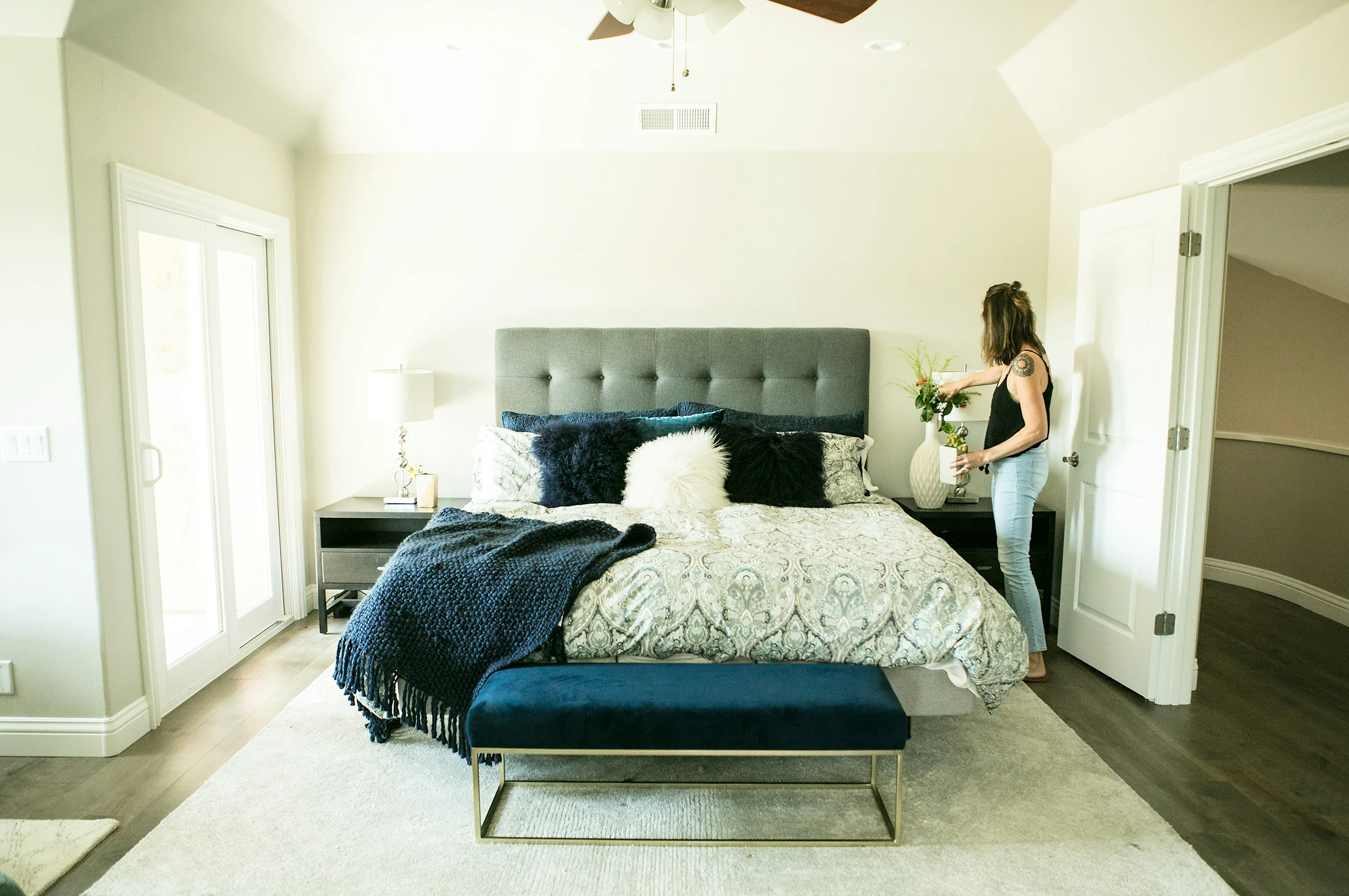 A made bed with a dark headboard in a bright bedroom