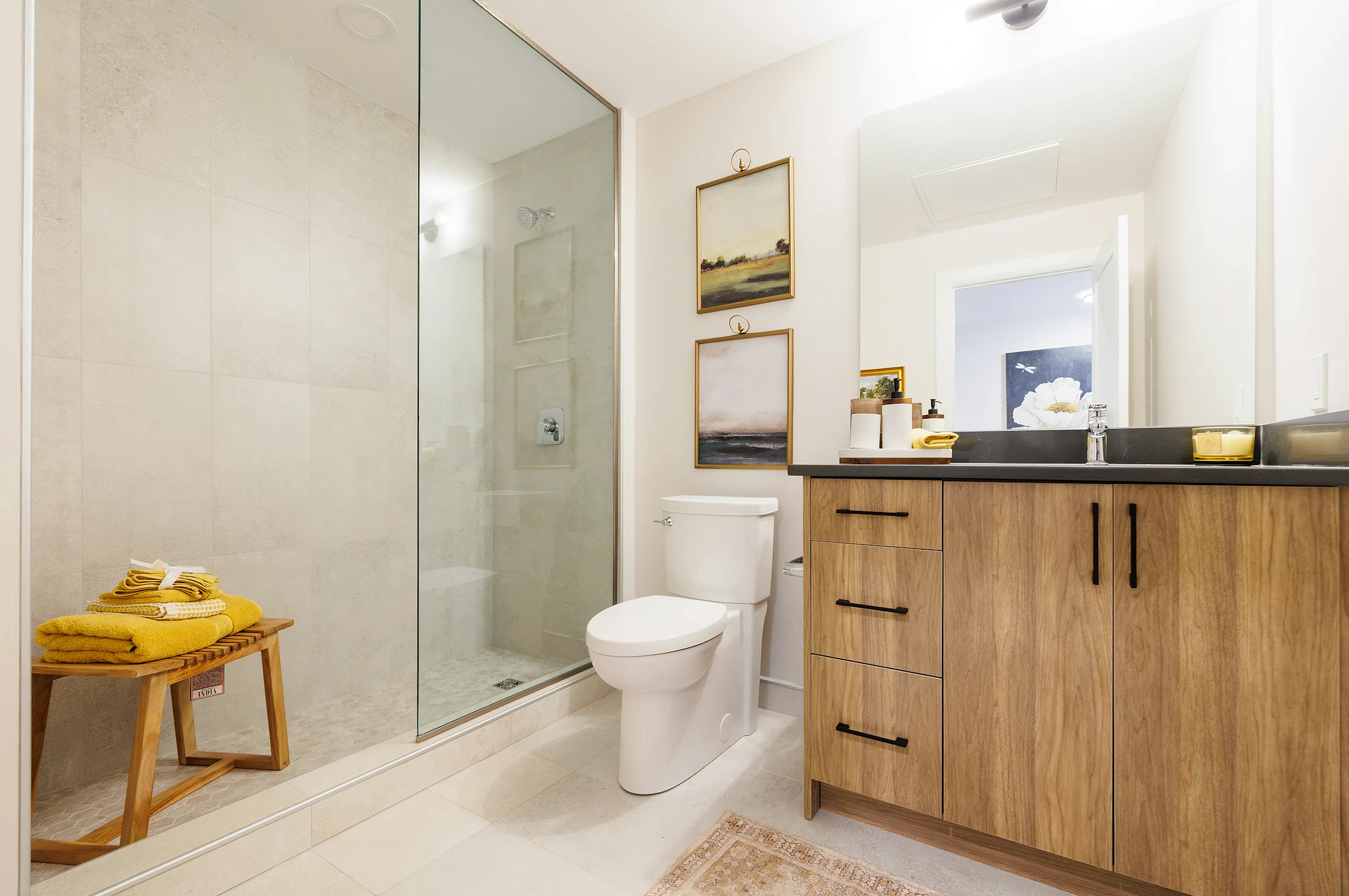 A clean bathroom with a glass shower and wooden vanity