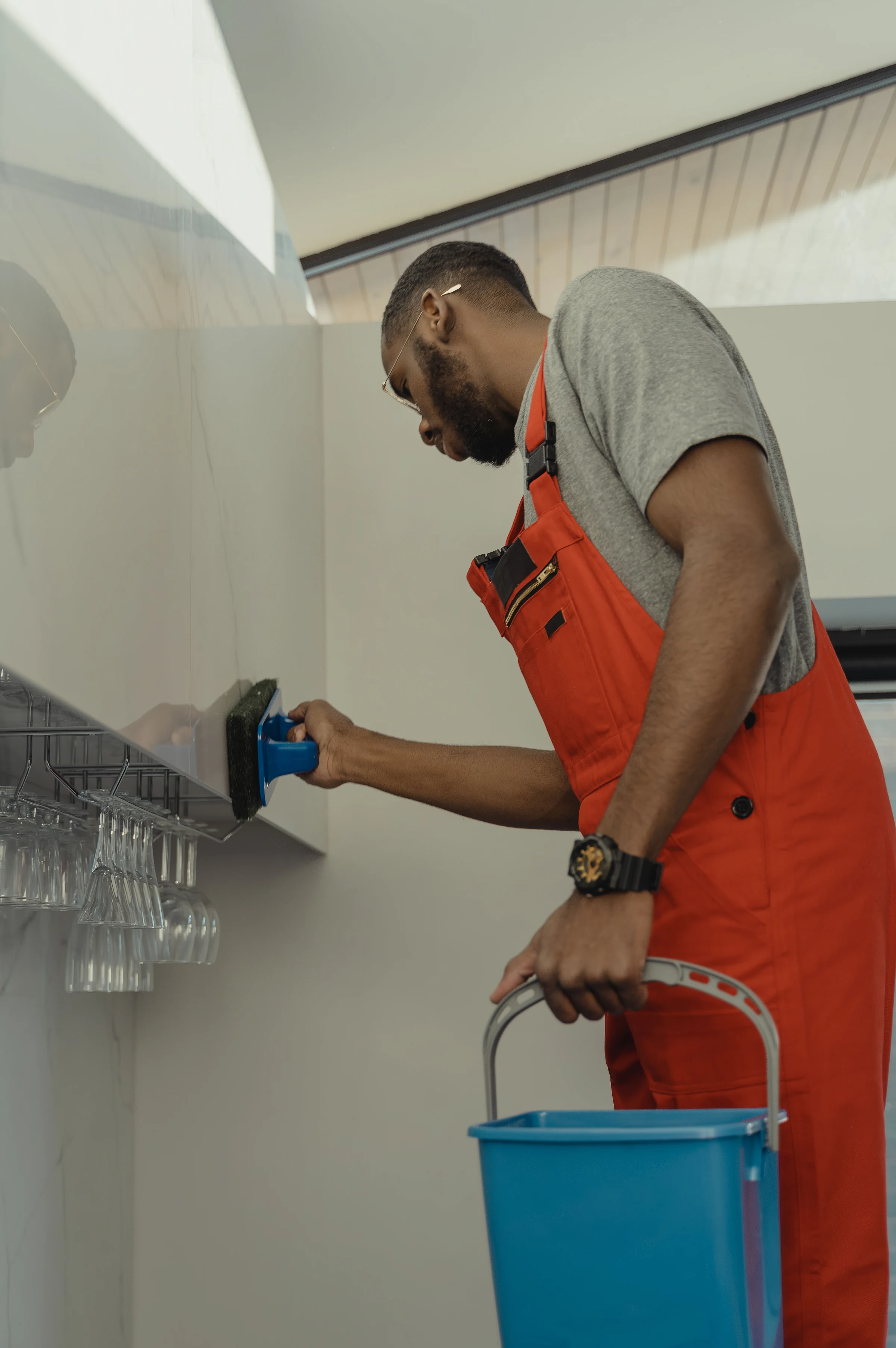 Bathrooms: a cleaner in overalls at work